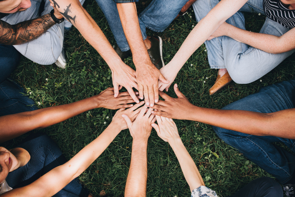 people-stacking-hands-together-park